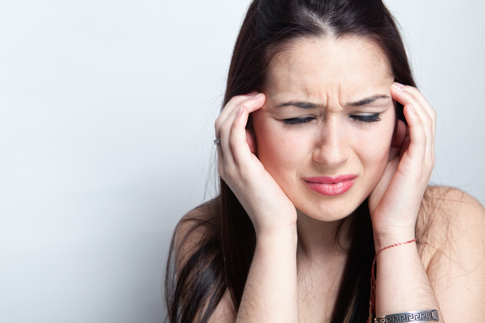 Headache concept - young woman suffering a migraine